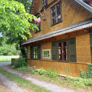 una casa de madera con 2 ventanas laterales en Domek wycieczkowy 