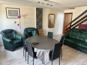 sala de estar con mesa y muebles de cuero verde en Lóczy-Lak, en Siófok