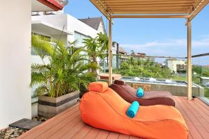 une chaise de sac orange assise sur une terrasse dans l'établissement ECHO BEACH DESIGNER APARTMENT, à Canggu
