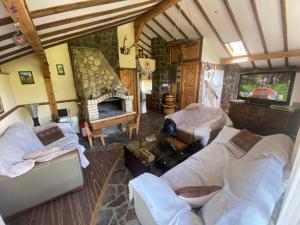 a living room with two beds and a fireplace at КЪЩА ЗА ГОСТИ ВОДЕНИЦАТА in Devin