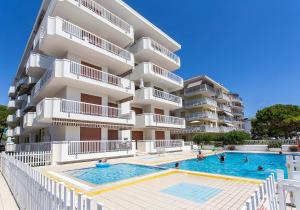 um hotel com piscina em frente a um prédio em Appartamento Nautilus em Lido di Jesolo