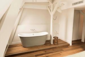 a bathroom with a bath tub on a wooden floor at Boutique Hotel Weesp in Weesp