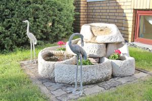 dos estatuas de pájaros de pie en una fuente en Ferienwohnung Spreemitte, en Lübbenau