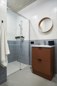 a bathroom with a shower with a sink and a mirror at Chill Inn in Łódź