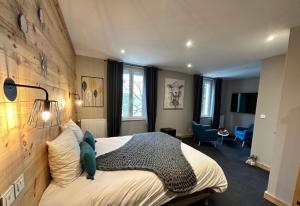 1 dormitorio con 1 cama grande y pared de madera en Hôtel-Restaurant La Bergerie, en Sévérac d' Aveyron