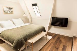 a bedroom with a bed and a flat screen tv at Boutique Hotel Weesp in Weesp