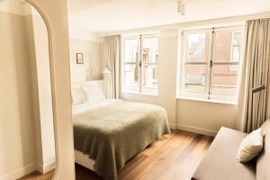 a bedroom with a bed and two windows at Boutique Hotel Weesp in Weesp