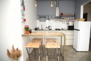 cocina con encimera con taburetes y nevera en NEW! Cozy stylish apartment with breathtaking view, en Tiflis