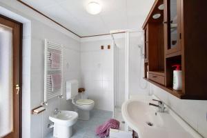 Baño blanco con aseo y lavamanos en Alla meridiana, en Bard