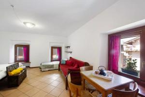 a living room with a red couch and a table at Alla meridiana in Bard