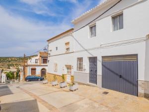 une maison blanche avec un garage et une voiture dans l'établissement Cubo's Casa Camino del Cantinero, à Ardales