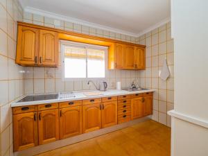 a kitchen with wooden cabinets and a window at Cubo's Casa Camino del Cantinero in Ardales