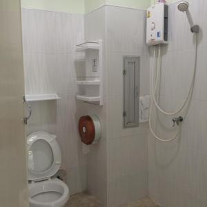 a small bathroom with a toilet and a shower at Papangkorn House in Suratthani