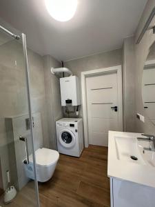 La salle de bains est pourvue d'un lave-linge et d'un sèche-linge. dans l'établissement Sosnówka Lake Apartament, à Sosnówka