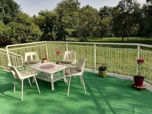 patio z 3 krzesłami i stołem na tarasie w obiekcie Villa Nora Garden w Sarajewie