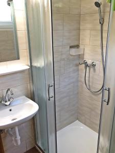 ein Bad mit einer Dusche und einem Waschbecken in der Unterkunft Süle Apartments & Rooms in Balatonfüred
