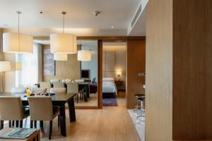 a dining room and living room with a dining table at Marriott Executive Apartments Bangkok, Sukhumvit Thonglor in Bangkok