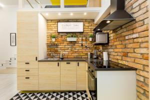 a kitchen with a brick wall and a counter at Pastel paradise with a ray of sunshine in Budapest