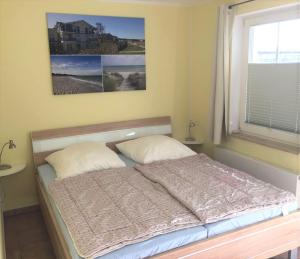 a bed with two pillows in a room with a window at Strandtraum in Glowe