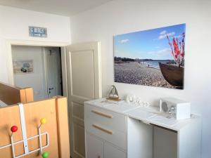 a room with a white desk with a picture on the wall at Strandtraum in Glowe