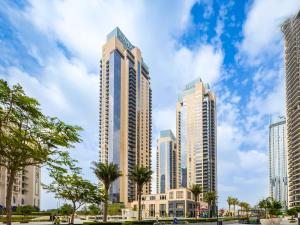 un groupe de grands bâtiments dans une ville dans l'établissement Cosmos Living - Dubai Creek Harbour, à Dubaï