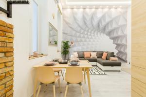 a living room with a table and chairs and a couch at Pastel paradise with a ray of sunshine in Budapest
