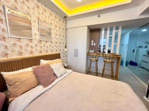 een slaapkamer met een bed en een bar bij Chic Hideaway at Azure North Bali Tower in San Fernando