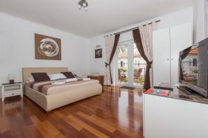 a bedroom with a bed and a flat screen tv at Apartments Casa Toni Dubrovnik in Dubrovnik