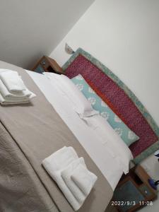 een slaapkamer met een bed met twee handdoeken erop bij B&B SA CROBE in Lanusei