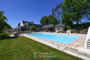 a swimming pool in the backyard of a house at Domaine Paysager de Kertanguy in Garlan