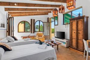Una sala de estar con dos camas y un televisor. en Villa Rosa 5 - PlusHolidays, en Altea