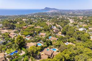 Una vista aérea de una casa con árboles y el océano. en Villa Rosa 5 - PlusHolidays, en Altea