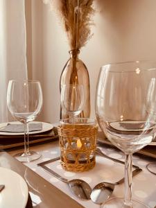 a table with three wine glasses and a vase at NatySweethome in Magny-le-Hongre