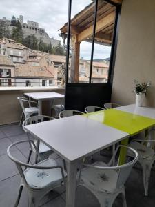 a row of tables and chairs with a view of the city at Les MIRABELLES chambres d'hôtes in Sisteron