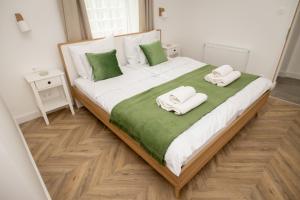 een slaapkamer met een groot bed en handdoeken bij Villa GreenTree - Fully Refurbished in 2023 in Budakalász