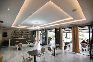 un ristorante con tavoli e sedie e un bar di Hotel Roalb a Vlorë