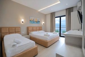 een hotelkamer met twee bedden en een wastafel bij Hotel Roalb in Vlorë