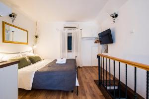 - une chambre avec un lit et une télévision à écran plat dans l'établissement Apartments Leticia, à Split