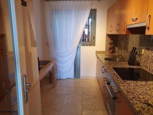 uma cozinha com uma cortina branca na porta em Royal Apartment 2 /freeWiFi,sharedpool,freeparking em Málaga