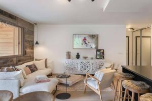 ein Wohnzimmer mit einem weißen Sofa und Stühlen in der Unterkunft Quintessence - Apt B202 - BO Immobilier in Châtel
