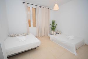Una habitación blanca con dos camas y una ventana. en For You Rentals Hermoso apartamento TEMPORAL Plaza Zerolo - Chueca - Madrid INF1F, en Madrid