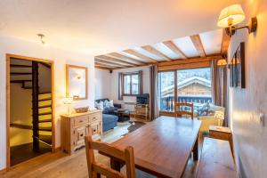 APARTMENT CHAMOUNY - Alpes Travel - Chamonix - Sleeps 8 في شامونيه مون بلان: غرفة معيشة مع طاولة خشبية وغرفة طعام