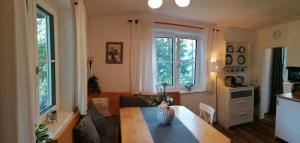 salon z drewnianym stołem i 2 oknami w obiekcie Ferienhaus Tauernblick w mieście Sankt Veit im Pongau