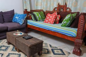 a living room with a couch and pillows at Serene 2 bedroom homestay 15mindrive to the beach in Mombasa