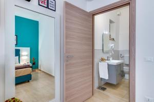 a bathroom with a wooden door leading to a bedroom at Anima Rooms Apartments in Sciacca