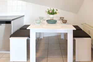 a kitchen with a white table with flowers on it at Ferienwohnung Orchidee in Lübbenau