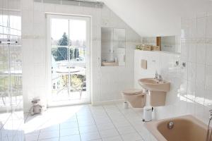 ein weißes Bad mit einem WC und einem Waschbecken in der Unterkunft Ferienwohnung Orchidee in Lübbenau