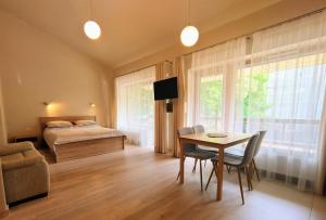 a bedroom with a bed and a table and chairs at Anbo Vila in Palanga