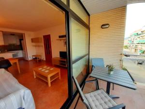 a room with a balcony with a table and a couch at HomeHolidaysRentals Bijou - Costa Barcelona in Pineda de Mar