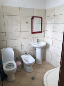 a bathroom with a toilet and a sink at Bujtina Vrenezi in Peshkopi